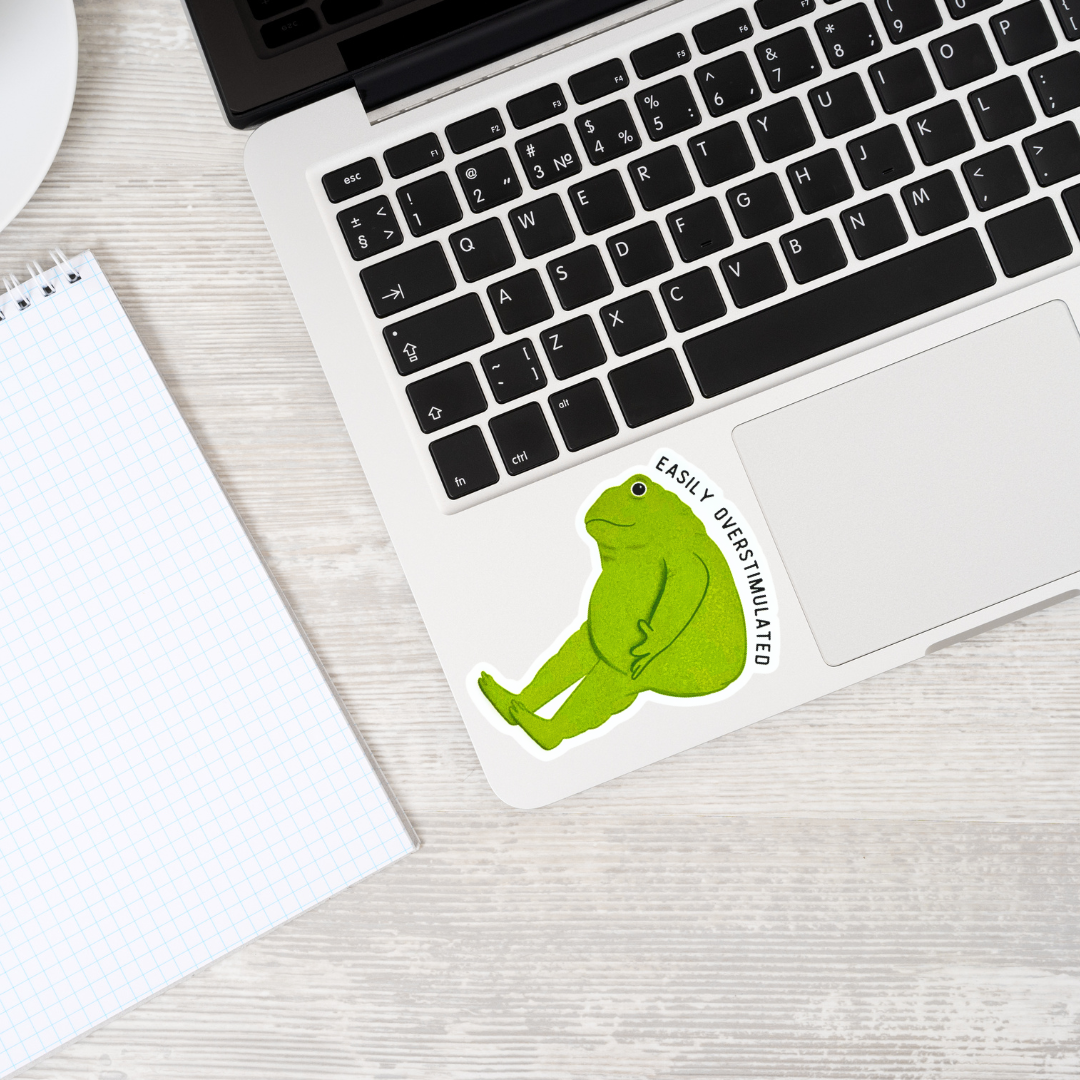 Green frog sticker on a laptop, showcasing its humorous and relatable design